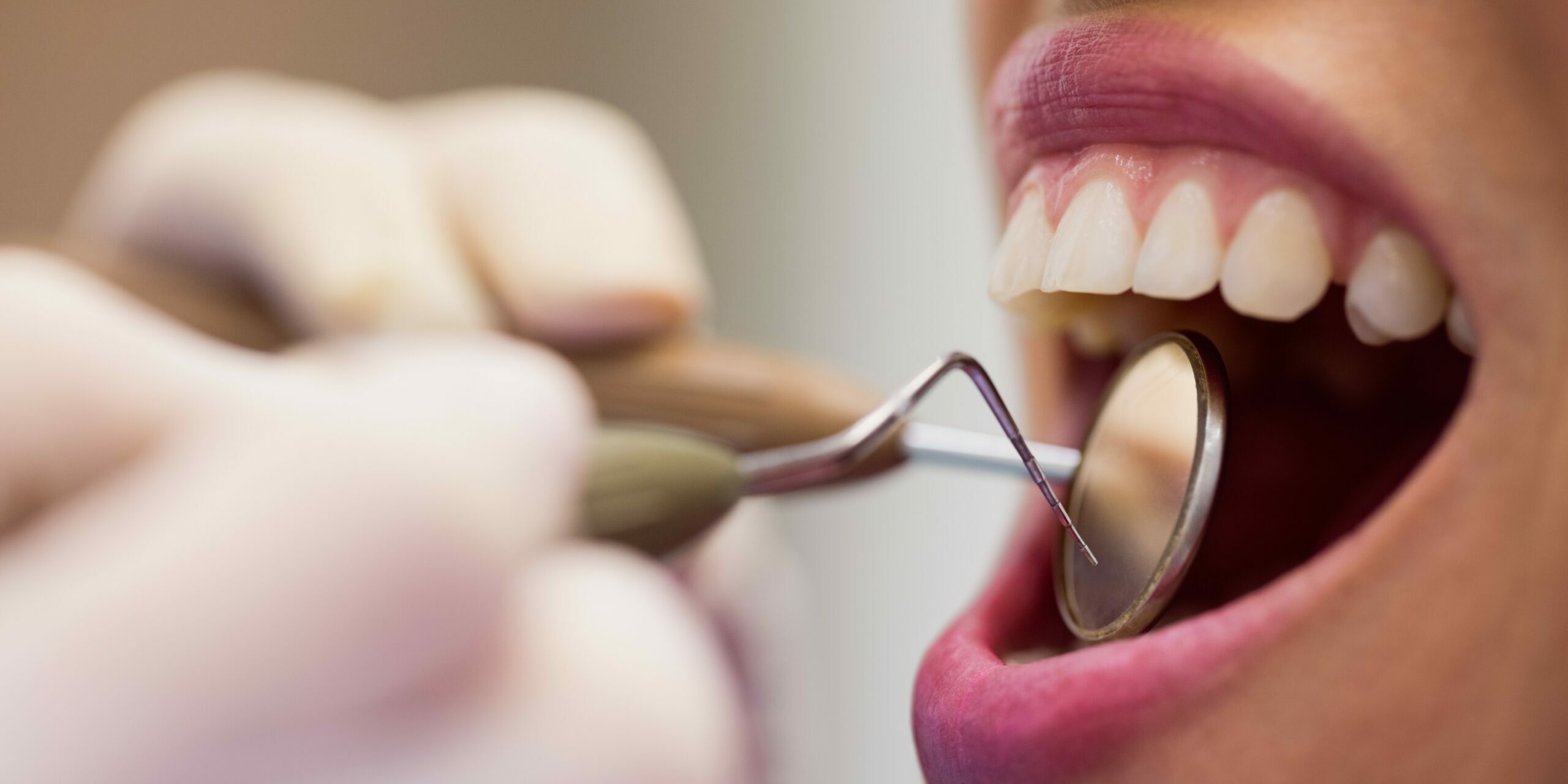 Dentist examining a female patient with tools